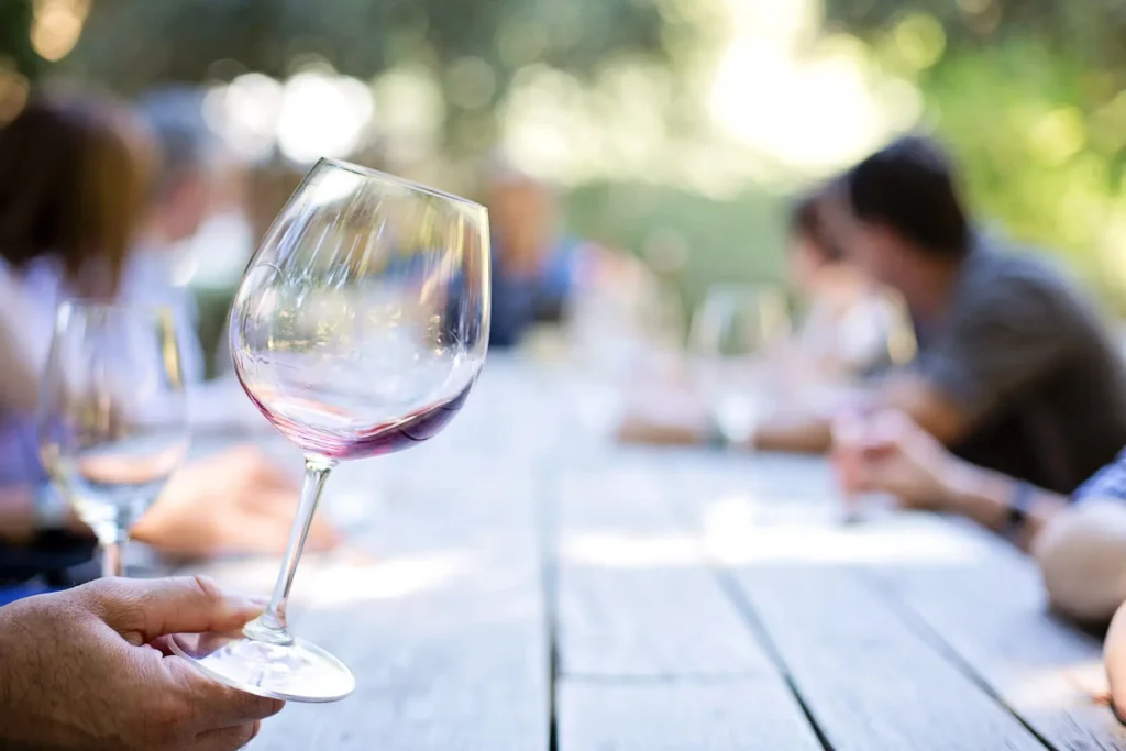 A table of people with glasses of wine in hand, outdoors