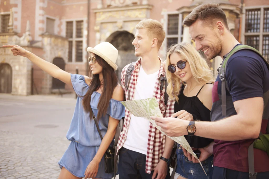 In the picture, a group of four young people looking at a map.